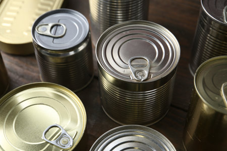 Many closed tin cans on wooden table, closeupの写真素材