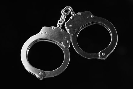 Metal chain handcuffs on black background, closeupの写真素材