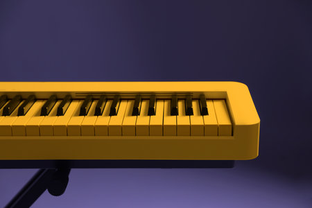 Yellow synthesizer on purple background, closeup. Electronic musical instrumentの写真素材