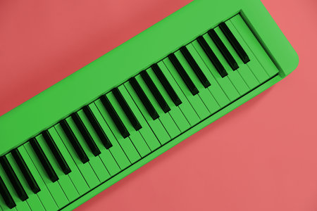 Green synthesizer on pink background, top view. Electronic musical instrumentの写真素材