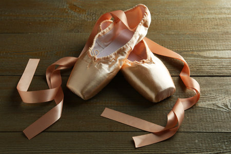Pair of beautiful pointe shoes on wooden tableの写真素材
