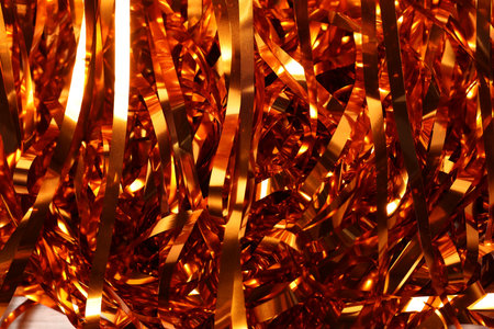 Shiny golden tinsel as background, closeup viewの写真素材