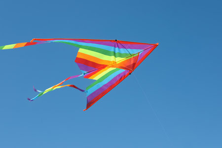 One colorful kite flying in blue skyの写真素材