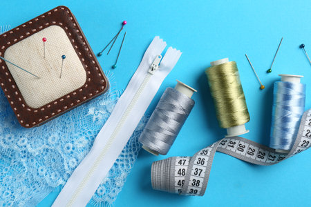 Different sewing supplies on light blue background, flat layの写真素材