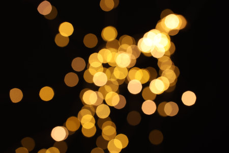 Blurred view of golden lights on black background, bokeh effectの写真素材