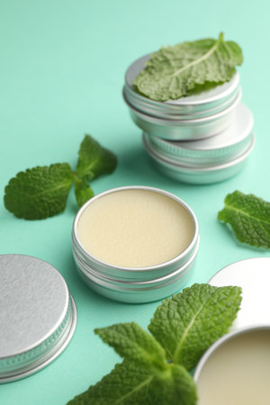 Natural lip balms and mint leaves on turquoise background, closeupの写真素材