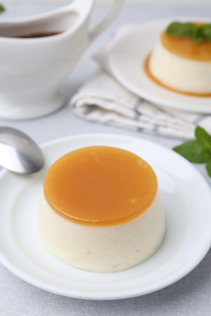 Tasty pudding with caramel sauce served on white table, closeupの写真素材