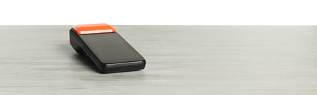 Payment terminal on wooden table against white backgroundの写真素材