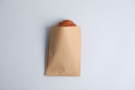 Paper bag with freshly baked bun on white background, top viewの写真素材