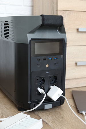 Modern portable power station, charging devices attached indoorsの写真素材