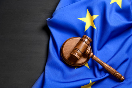 Judge's gavel and flag of European Union on gray wooden table, above view. Space for textの写真素材