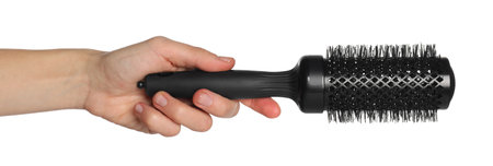 Hand holding round black hair brush on white background, closeupの写真素材