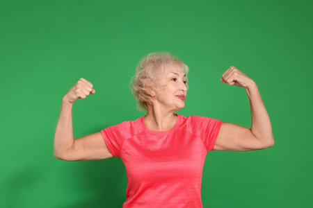 Senior woman exercising on green background. Healthy lifestyleの写真素材