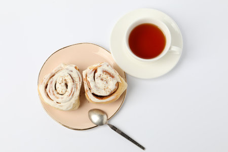 Cinnamon rolls and tea on white table, flat layの写真素材
