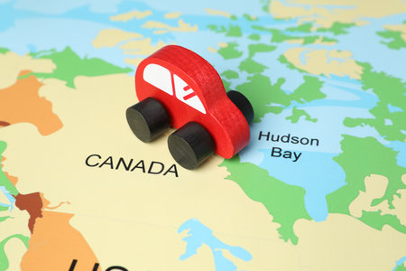 Red wooden toy car on world map. Road tripの写真素材