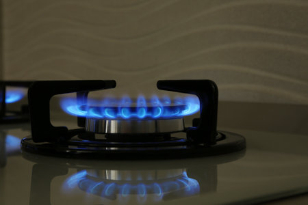 Gas burner of modern stove with burning blue flameの写真素材