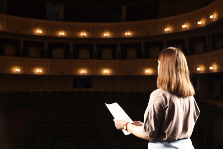 Professional actress rehearsing on stage in theatre, back viewの写真素材