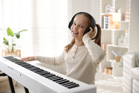 Cute girl in headphones playing at homeの写真素材