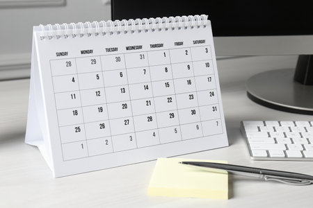 Timetable. Monthly planner, stationery and computer on white tableの写真素材