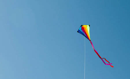 One colorful kite flying in blue sky. Space for textの写真素材