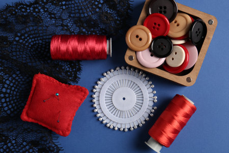 Different sewing supplies on blue background, flat layの写真素材