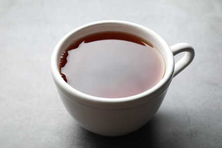 Refreshing black tea in cup on gray table, closeupの写真素材
