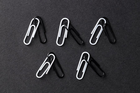 Many paper clips on black background, flat layの写真素材