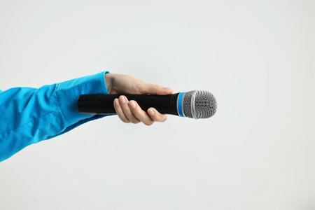 Woman with microphone on grey background, closeupの写真素材
