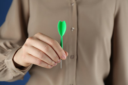 Woman holding dart on blue background, closeupの写真素材