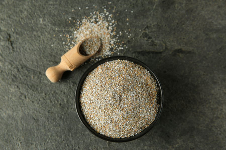 Fresh rye bran and scoop on grey textured table, flat layの写真素材
