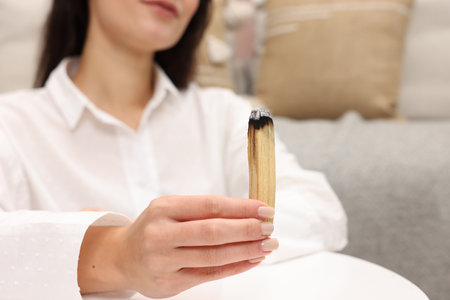 Woman with burnt palo santo stick at home, selective focusの写真素材