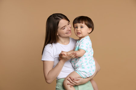 Family portrait of happy mother with her little son on beige backgroundの写真素材