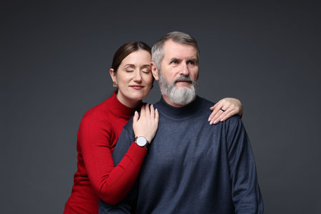Daughter and her father on dark background