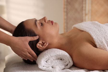 Young woman receiving massage in spa salonの写真素材