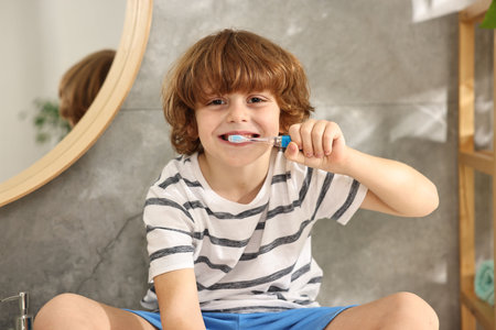 Cute boy brushing his teeth in bathroomの写真素材