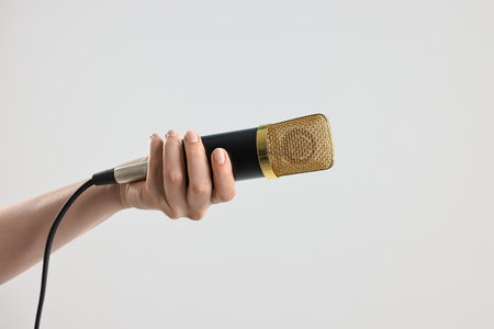 Woman with microphone on gray background, closeupの写真素材