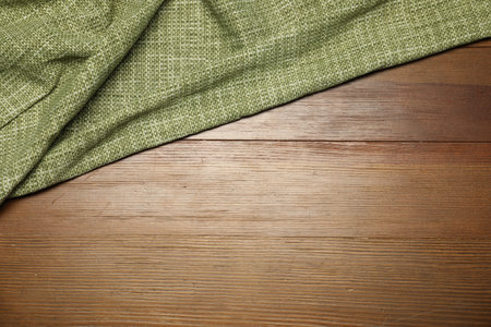 Green tablecloth on wooden background, top view. Space for textの写真素材