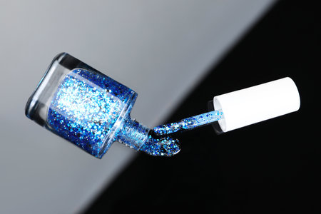 Open nail polish in bottle and brush on mirror surface, top viewの写真素材