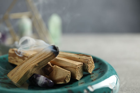 Smoldering palo santo stick and gemstone on table, closeupの写真素材