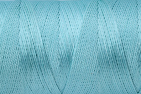 Light blue sewing thread as background, closeup