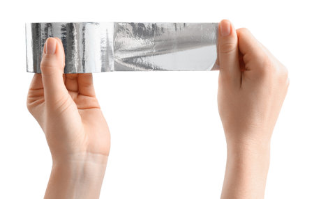 Woman with roll of silver adhesive tape on white background, closeupの写真素材