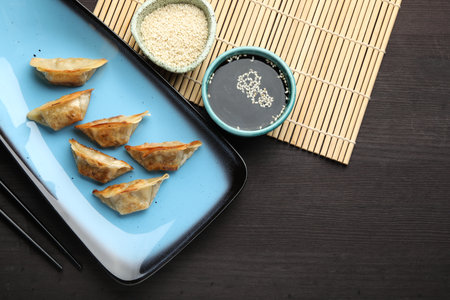Delicious fried gyoza dumplings served on wooden table, flat layの写真素材