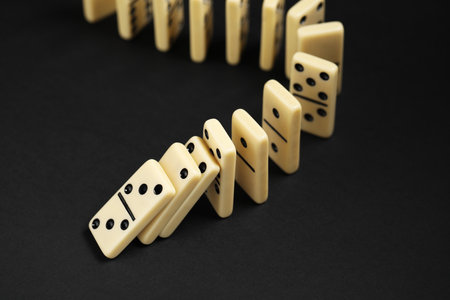 Domino effect. Tiles falling on black backgroundの写真素材