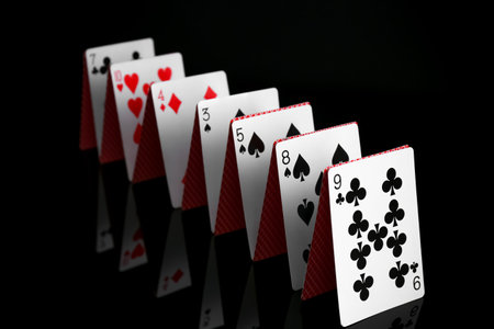 Row of playing cards on black mirror surface, closeupの写真素材