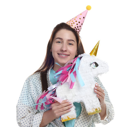 Happy woman with unicorn shaped pinata on white backgroundの写真素材