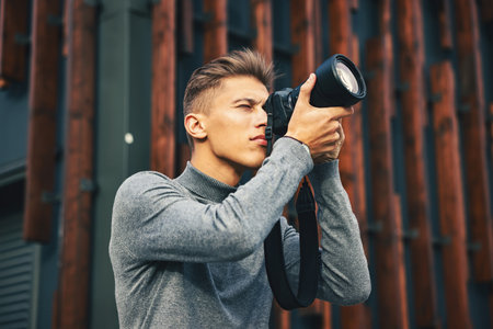 Professional photographer taking picture with camera outdoorsの写真素材