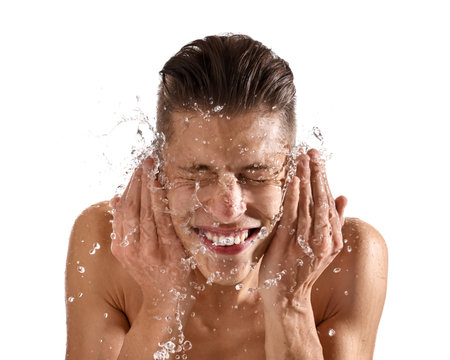 Smiling man washing his face on white backgroundの写真素材