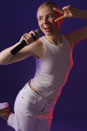 Beautiful talented singer performing on purple backgroundの写真素材