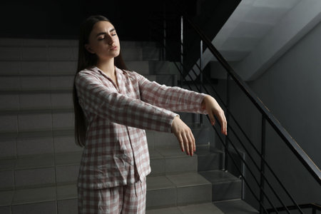 Woman suffering from sleepwalking on stairs indoorsの写真素材