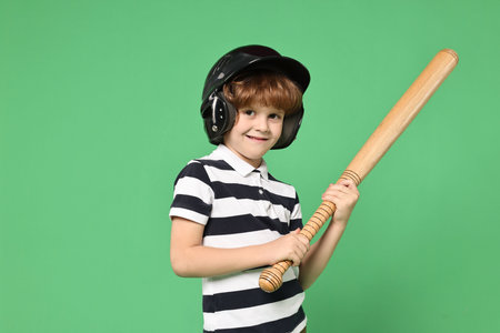 Little boy in helmet with baseball bat on light green backgroundの写真素材